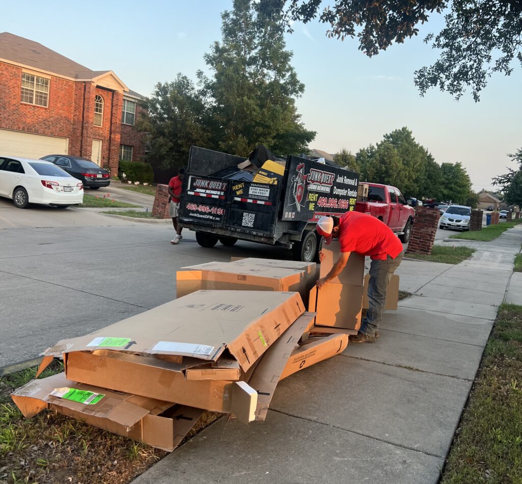 Junk Quest crew loading flattened cardboard and reusable materials into a trailer during an eco-friendly junk removal and upcycling service in North Texas.