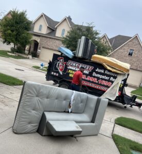 Junk Quest crew preparing to remove a sectional couch during a junk removal service — professional furniture pickup and hauling for North Texas homeowners.