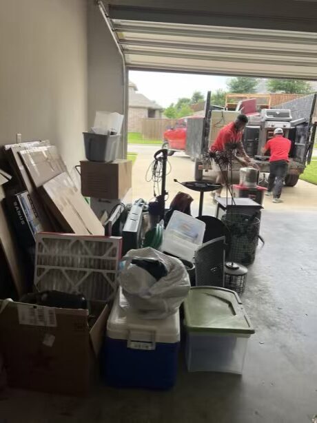 Junk Quest team loading boxes, bins, and clutter during a garage cleanout in McKinney, TX.