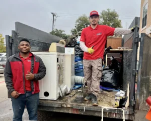Junk Quest crew loading bulky appliances and debris into a trailer during a professional junk removal service — trusted local team providing residential and commercial cleanouts across North Texas.