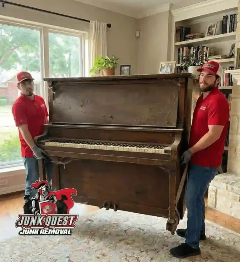 Junk Quest team hauling a large piano out of a home during a professional piano removal service in McKinney, TX