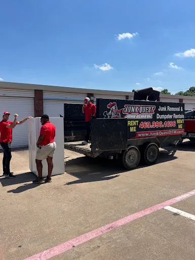 Junk Quest Removal crew loading a large appliance into a trailer during professional appliance removal in North Dallas
