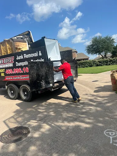 Junk Quest Removal team member loading an old appliance into a truck during appliance removal in North Dallas