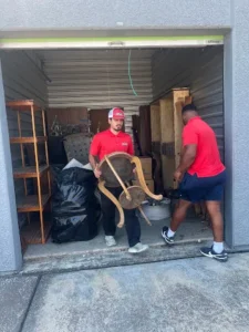 Junk Quest Removal team removing furniture from a storage unit during an estate cleanout in North Dallas