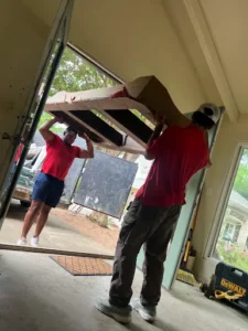 Junk Quest Removal team carrying bulky furniture during professional furniture junk removal in North Dallas