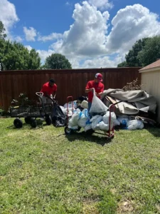 Junk Quest Removal crew hauling bags and debris during garage junk removal service in North Dallas