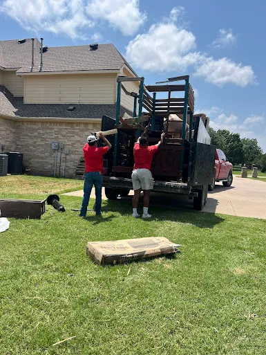 Junk Quest Removal crew loading old furniture into a truck during eco-friendly furniture disposal in North Dallas