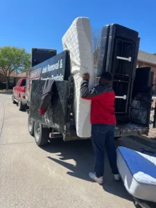 Junk Quest Removal team loading a mattress for donation or disposal in North Dallas