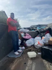 Junk Quest Removal team member standing inside a loaded trailer during a professional property cleanout in North Dallas