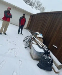 Garage cleanup after a winter storm in McKinney with debris, donation items, and discarded household materials