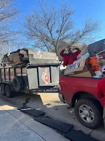 Junk removal trailer and pickup truck loaded with retail fixtures and debris during a North Dallas retail store cleanout