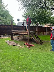 Junk Quest Removal crew dismantling wooden backyard structure during yard waste removal service in North Dallas