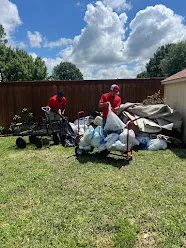 Junk Quest Removal crew loading yard debris bags and bulky waste during yard waste junk removal service in North Dallas