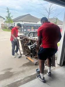 Junk Quest Removal crew lifting heavy metal equipment during scrap metal removal service in North Dallas