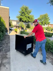 Junk Quest Removal worker hauling bulky debris during yard waste pickup service in North Dallas neighborhood