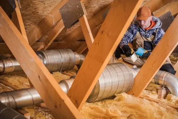 Technician clearing insulation and ductwork during an attic cleanout in Prosper, TX.