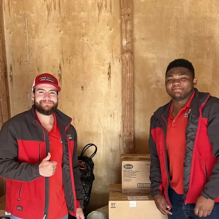 Junk Quest crew members giving a thumbs-up during a basement cleanout in North Dallas