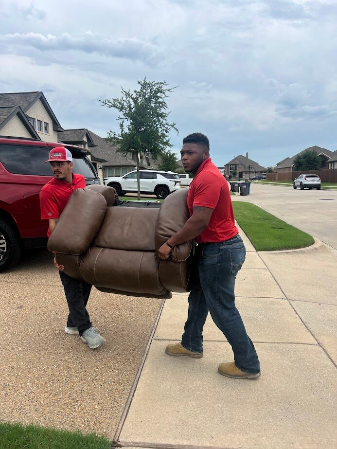 Junk Quest crew member carrying a recliner chair during a furniture removal job in North Dallas
