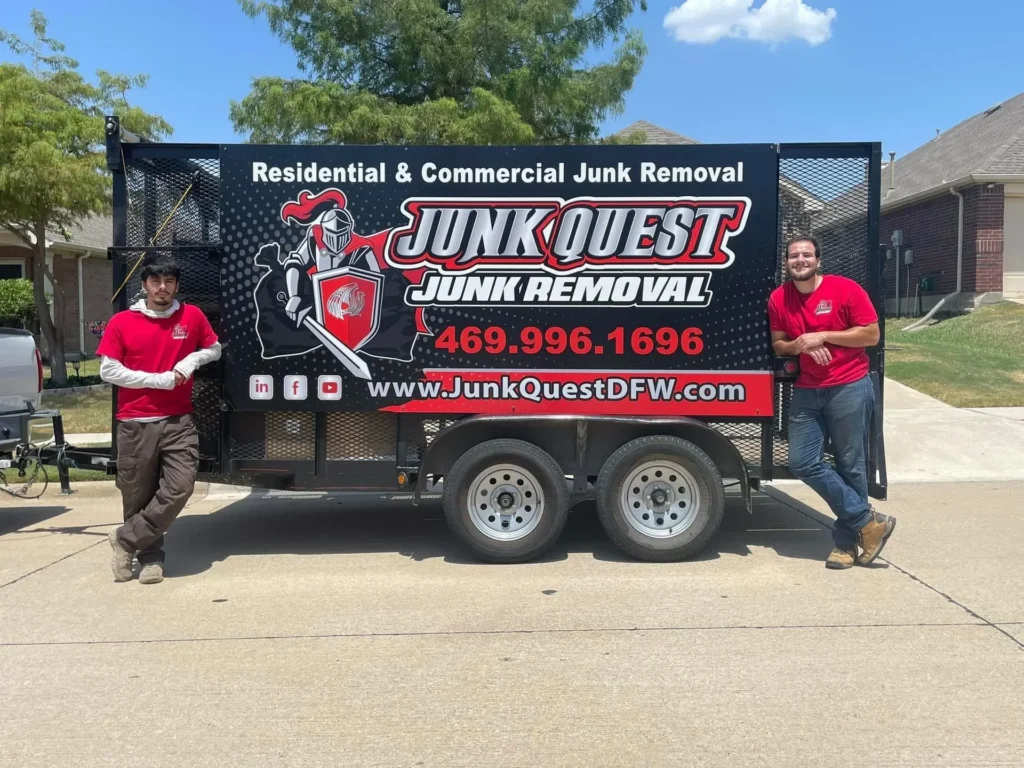 Junk Quest crew members standing beside their branded junk removal trailer