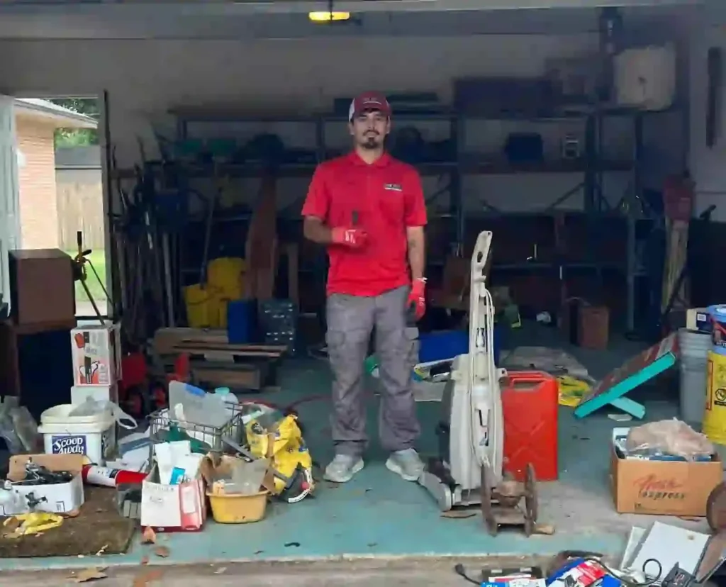 Junk Quest team member standing in a cluttered garage during a cleanout in Allen, TX.