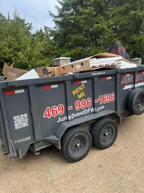 Junk Quest trailer loaded with debris and cardboard during a junk removal job