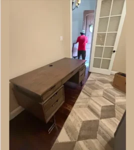 Junk Quest crew member removing a large office desk during a medical office cleanout in North Dallas TX